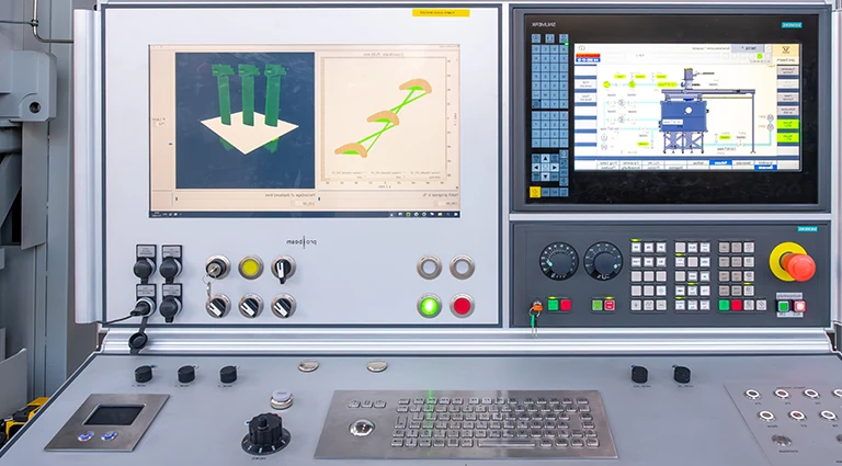 Nahaufnahme eines CNC-Maschinenbedienfelds mit mehreren Bildschirmen, auf denen 3D-Modellierungssoftware und Gerätesteuerungen, verschiedene Tasten, Schalter, Knöpfe und eine Tastaturschnittstelle angezeigt werden.